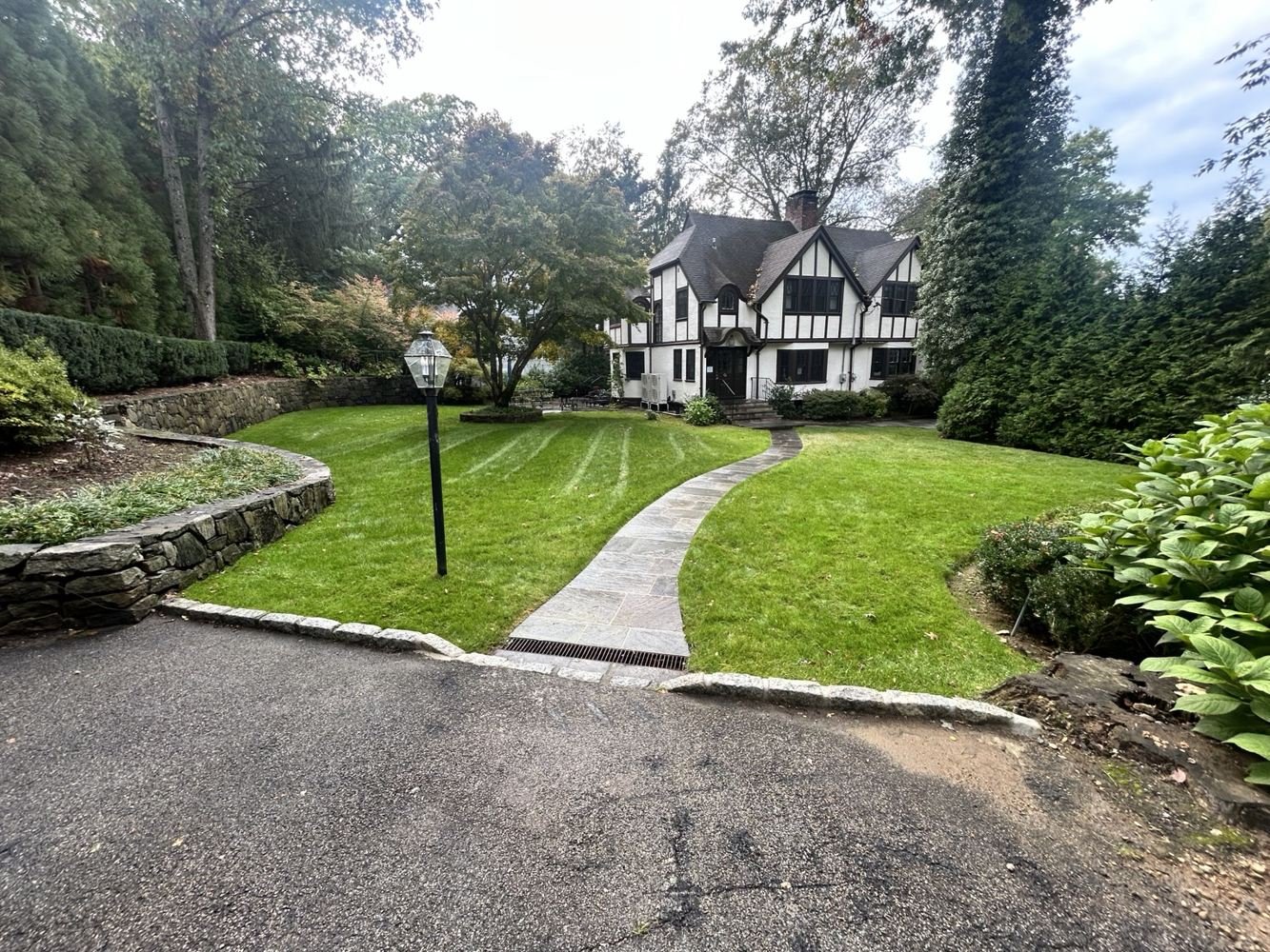 Landscaped home with a winding walkway and green lawn