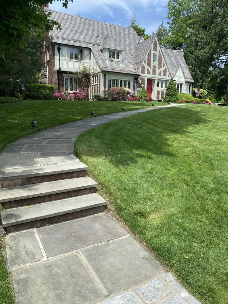 Stone steps and curved walkway through a neatly maintained lawn